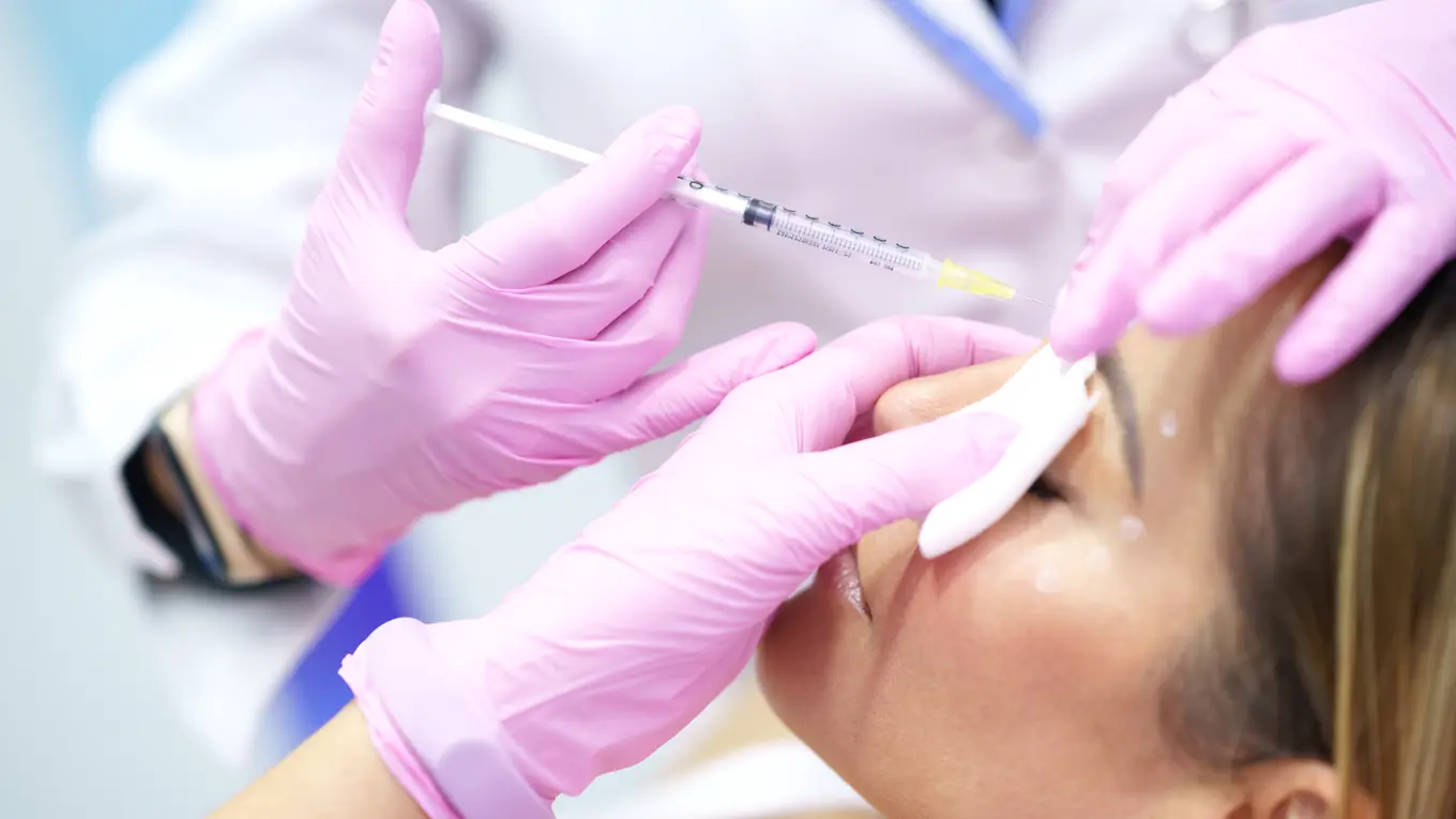 Doctor injecting filler into woman's face