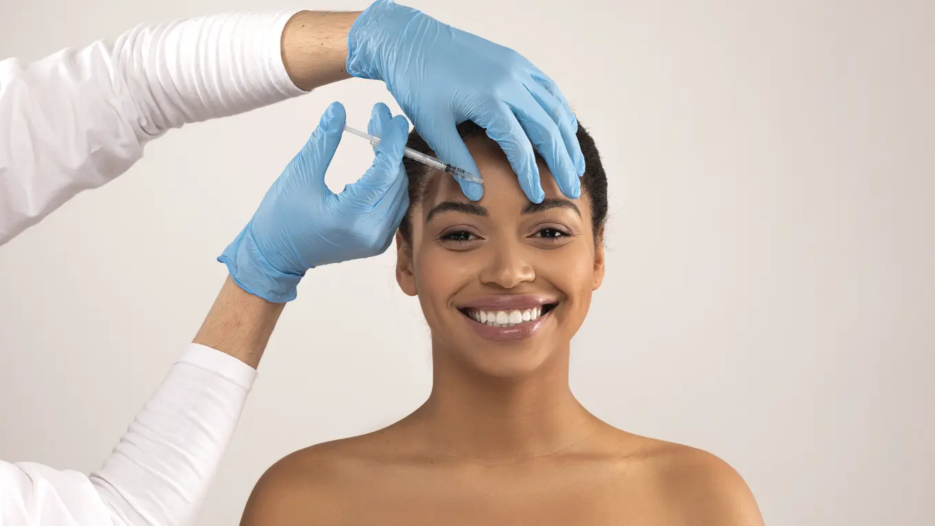 Woman receiving cosmetic facial injection with syringe