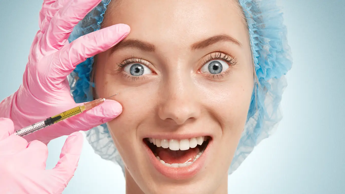 Woman receiving cosmetic injection near eye