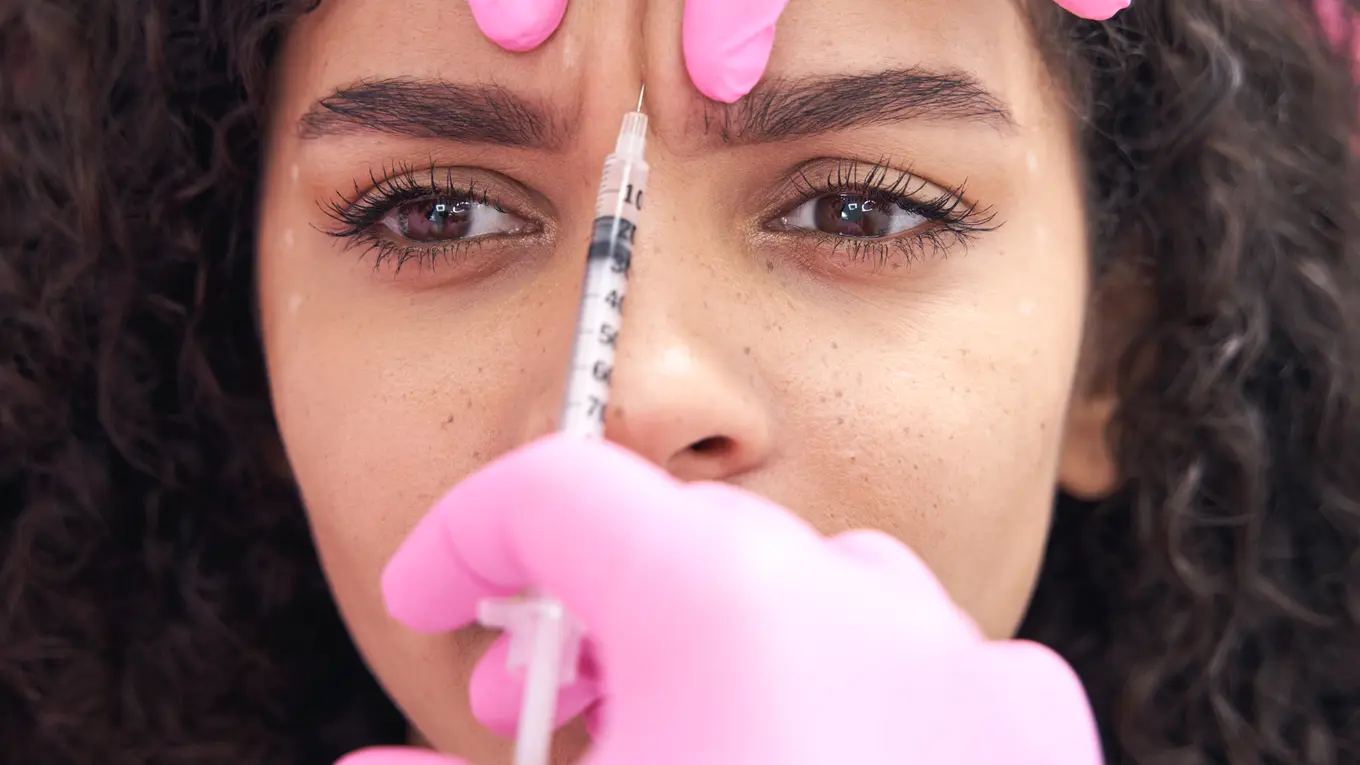 woman receiving cosmetic injection on forehead