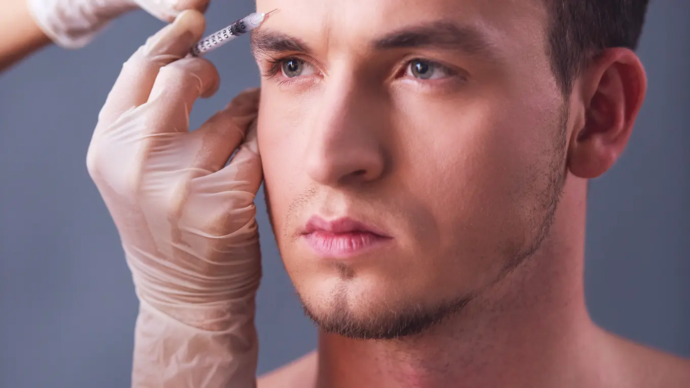 man receiving cosmetic injection on forehead